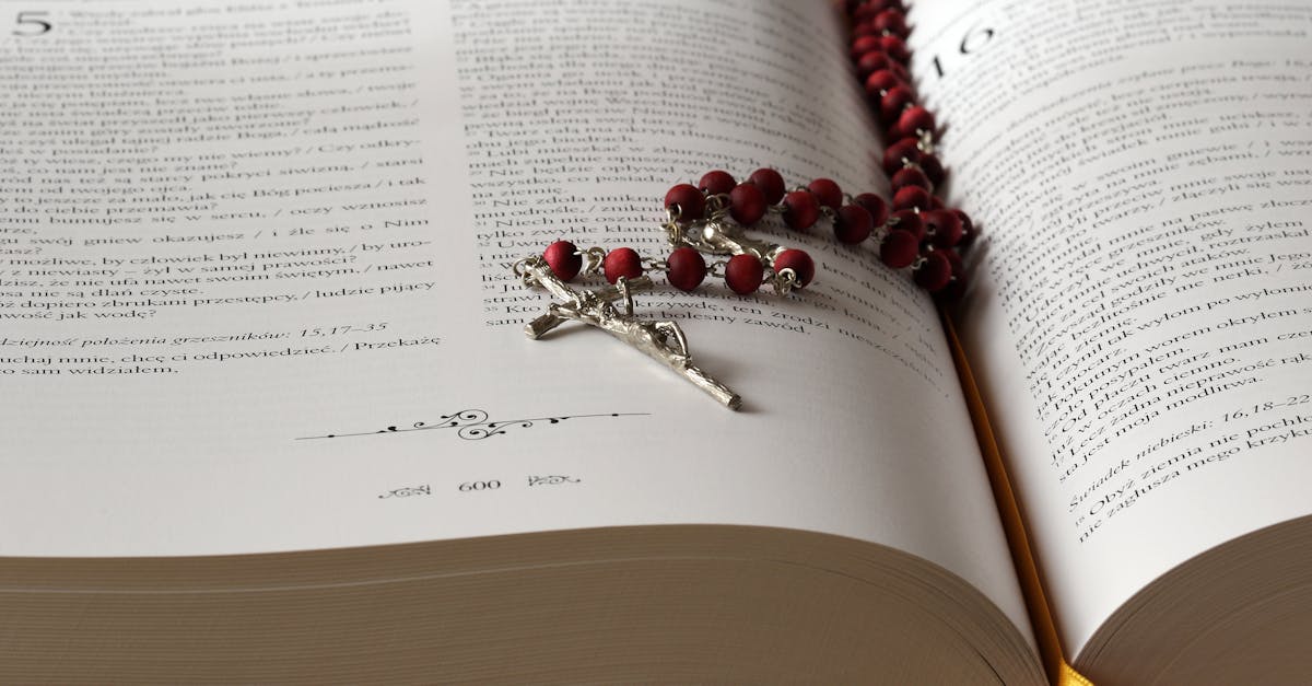 Open Bible with red rosary beads draped on pages, symbolizing faith and devotion.